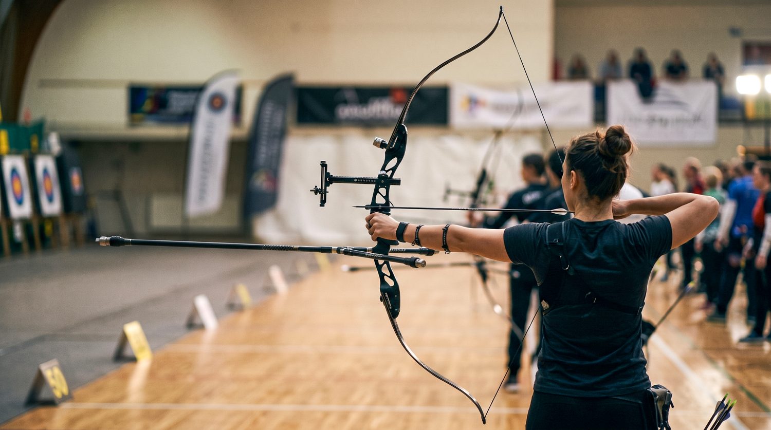 An elite recurve archer at full draw — the moment when limb stiffness, stabilizer damping, and steadiness all have to hold at once.